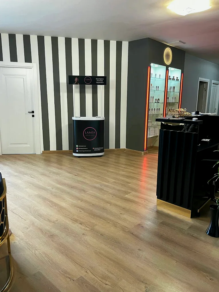 Salon girişi, çizgili duvar kaplaması ve yönlendirme standı